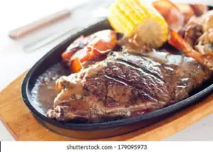 Cast Iron Hot Sizzling Plate On Wooden Tray