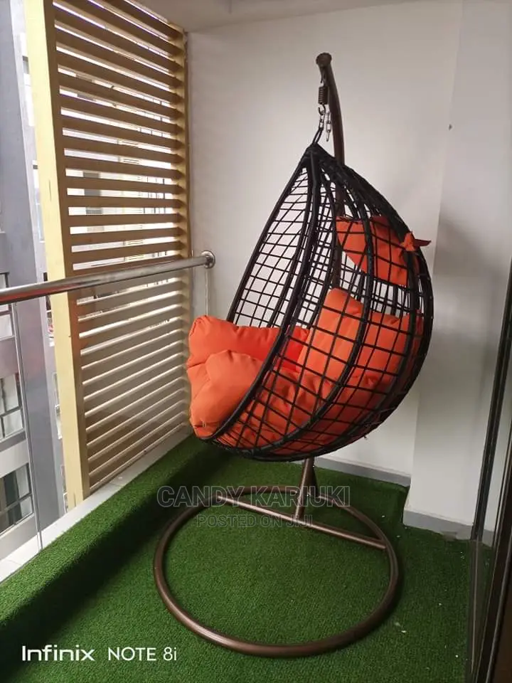 Balcony Swing With Orange Cushions and Brown Basket