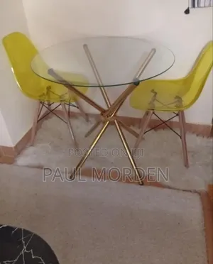 Outdoor Dining Table With Gold Stands and Two Dining Chairs