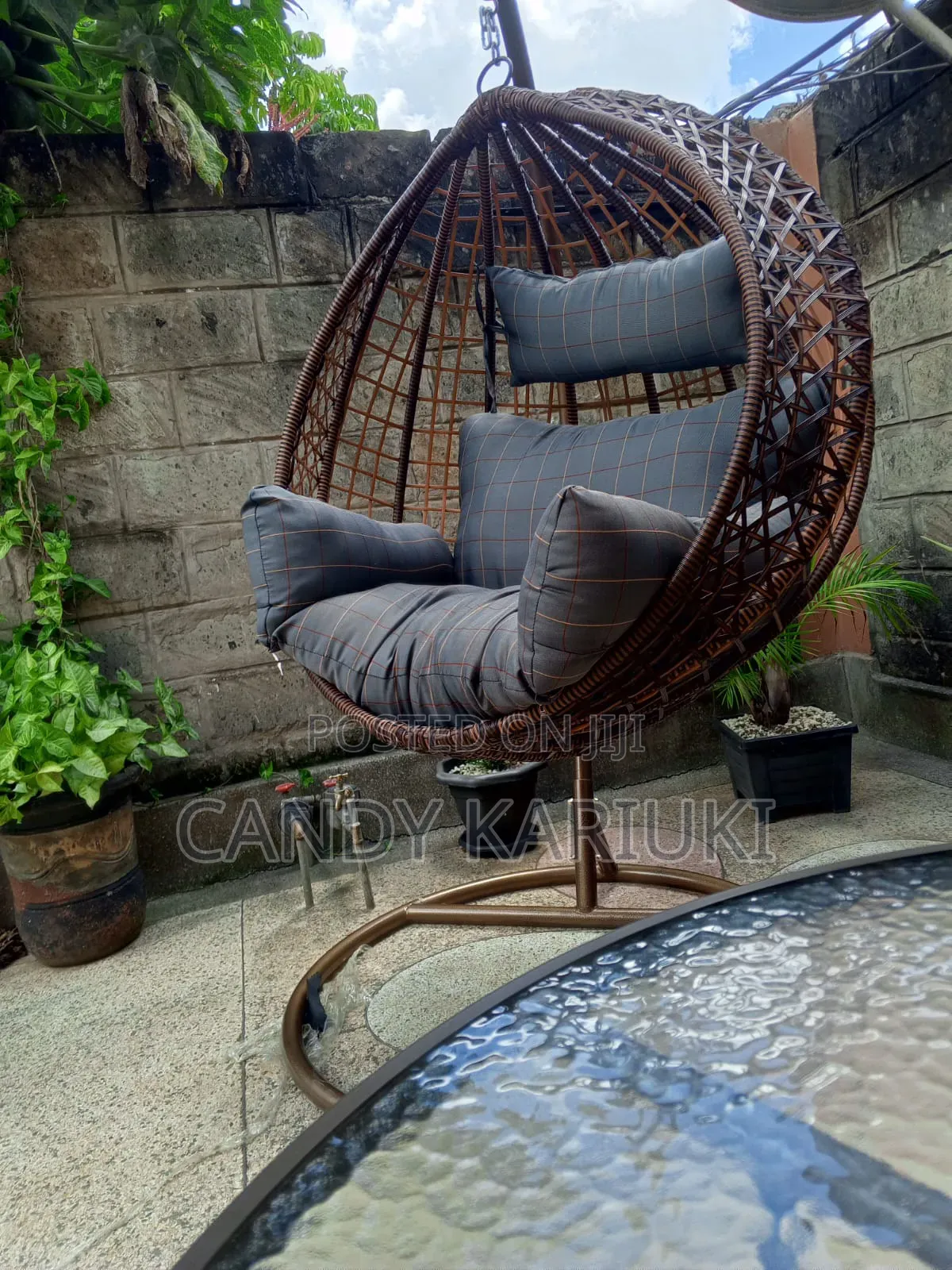 Brown Outdoor Swing With Checked Cushions