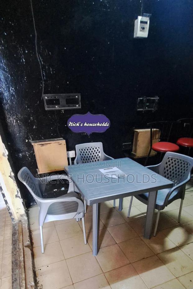 A Square Plastic Table With 3 Plastic Chairs With Metal Legs - main view