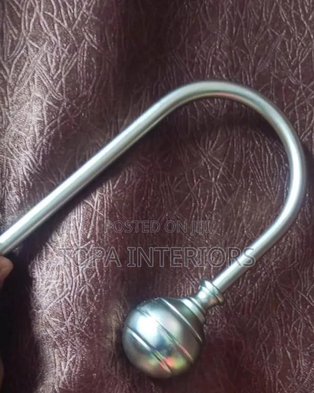 Metallic Curtain Tieback Hooks That Are Mounted on the Wall