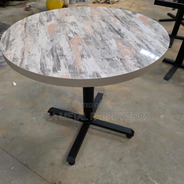 Glossy Restaurant Table, Circular With Sleek Metal Legs.