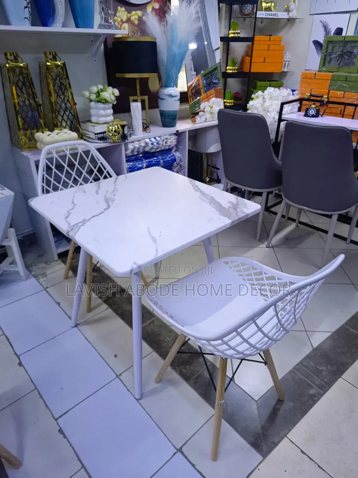 Modern Dinning Table With a Marble Effect Top With White Earmes Chairs