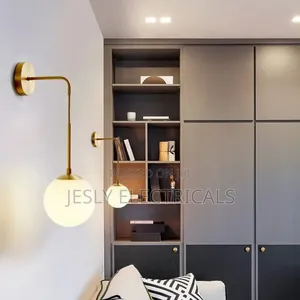 Modern Brass Wall Light With a White Glass Globe Shade.