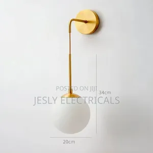 Modern Brass Wall Light With a White Glass Globe Shade.