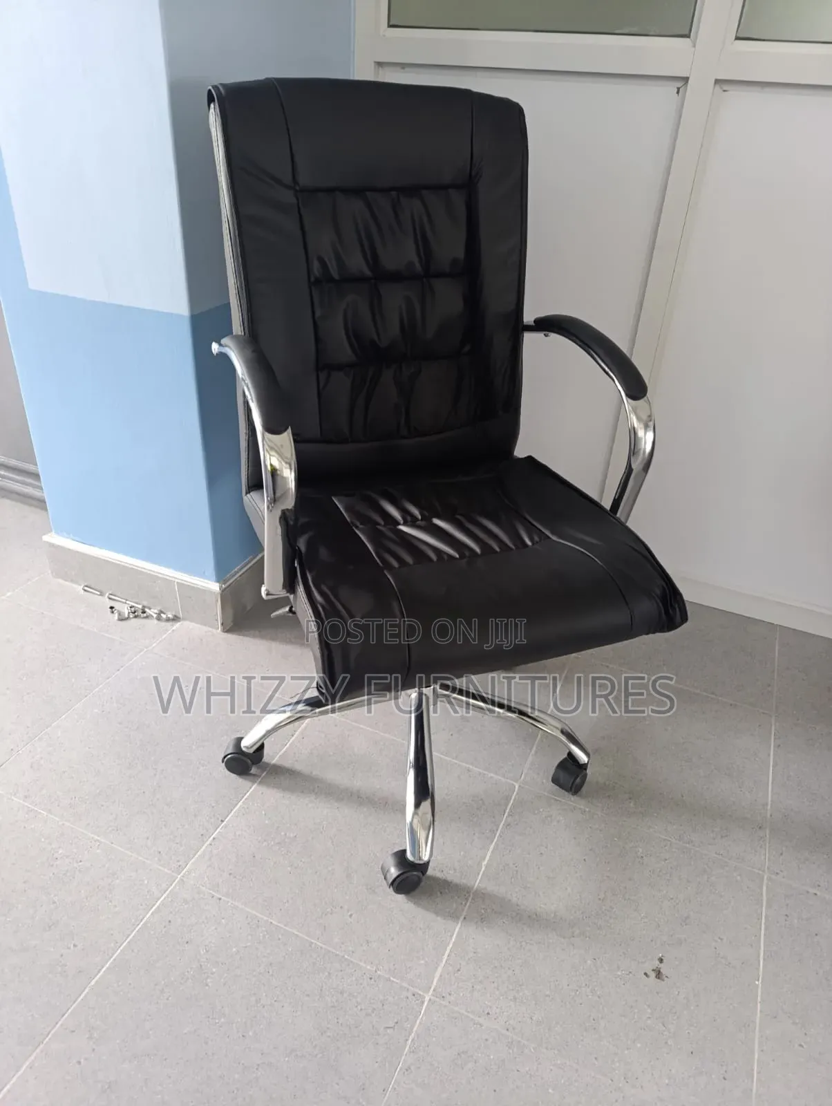 Black High-Back Executive Office Chair With a Chrome Base and Armrests