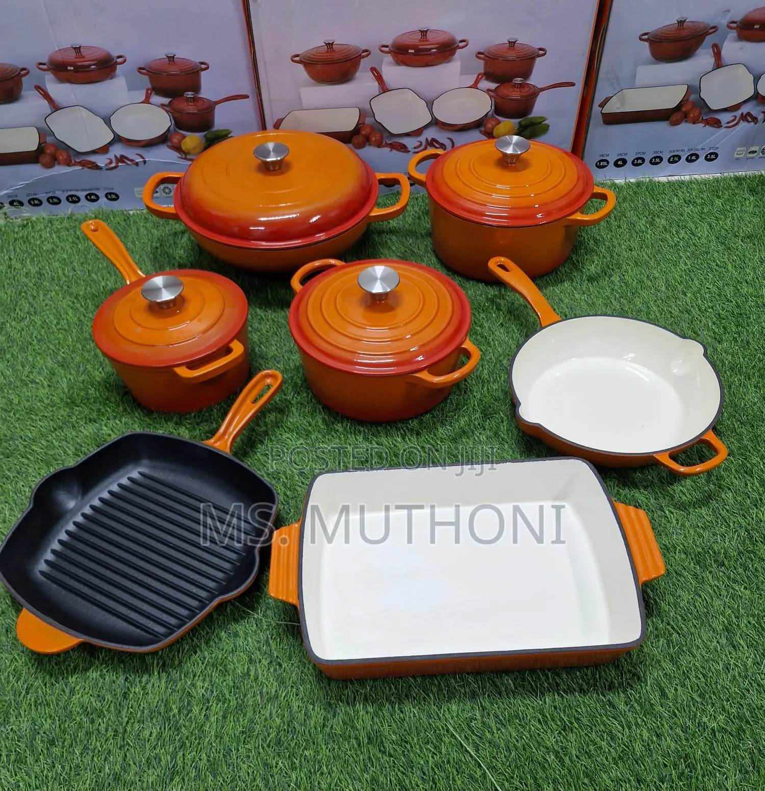 A Set of Enameled Orange Cast Iron Cookware With a Black Wok Pan