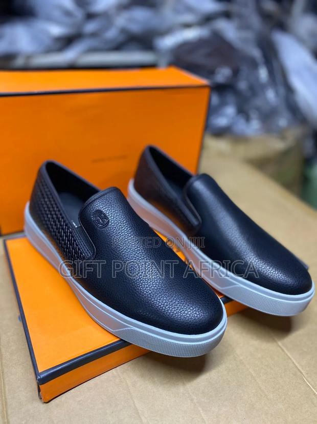 Men's Black Leather Slip-on Loafers With A White Sole.