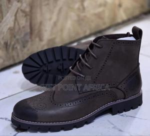 Brown Leather Wingtip Timberland Boots With A Lug Sole.
