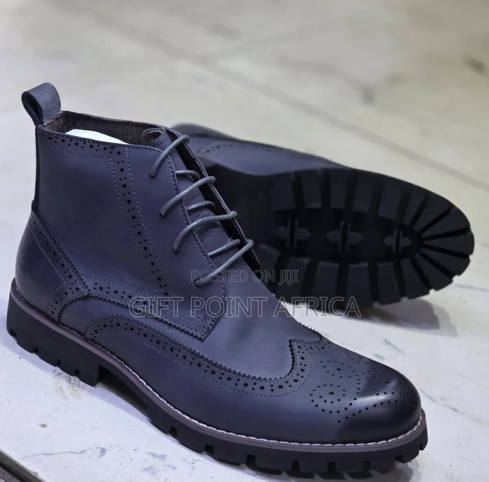 Brown Leather Wingtip Timberland Boots With A Lug Sole.