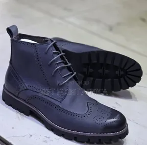 Brown Leather Wingtip Timberland Boots With A Lug Sole.