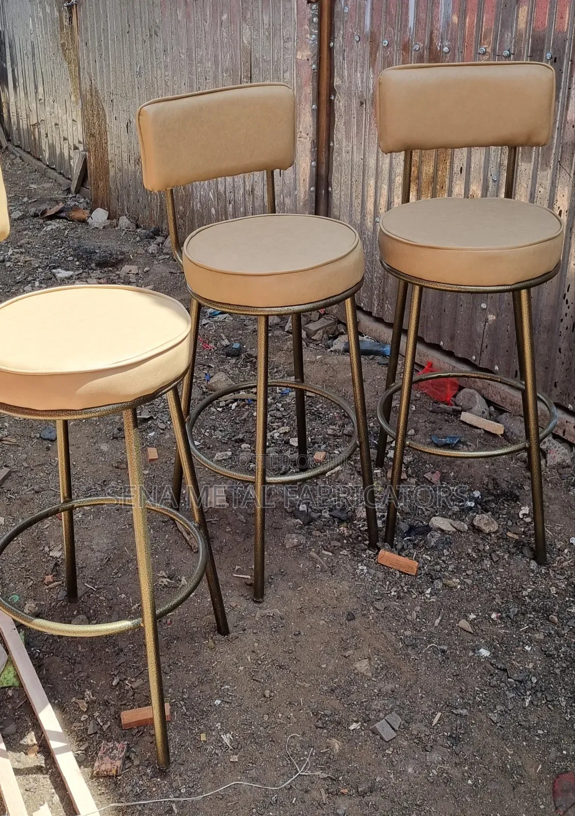 Powder-Coated Metal Bar Stool With Beige Upholstery.