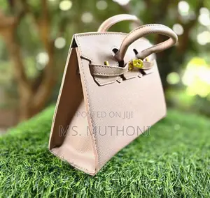 Textured Birkin Bag With an Adjustable Strap and Button Closure.