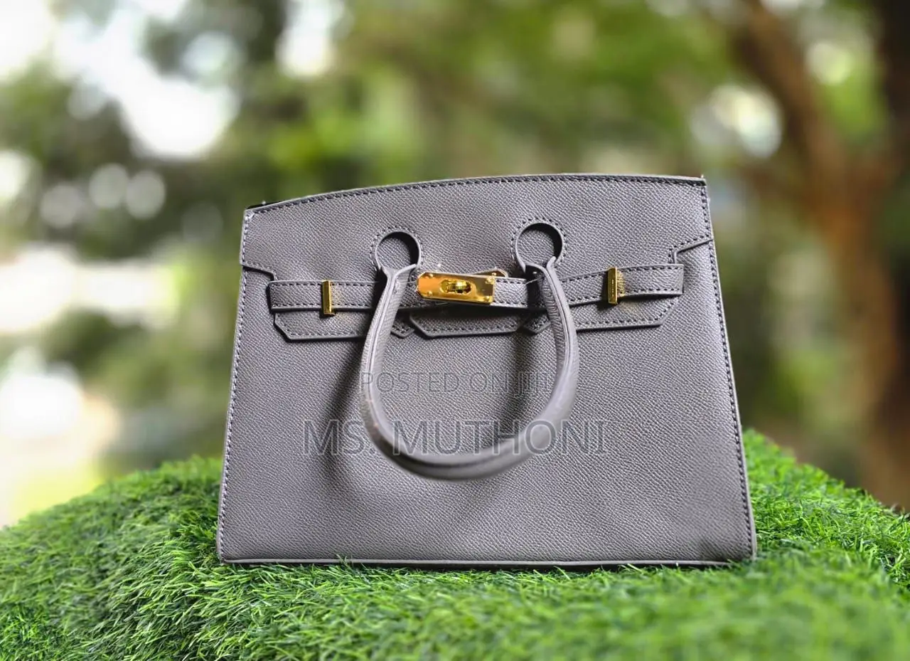 Textured Birkin Bag With an Adjustable Strap and Button Closure.