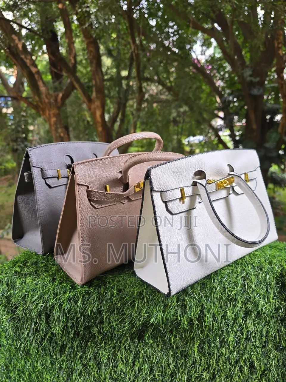 Textured Birkin Bag With an Adjustable Strap and Button Closure.