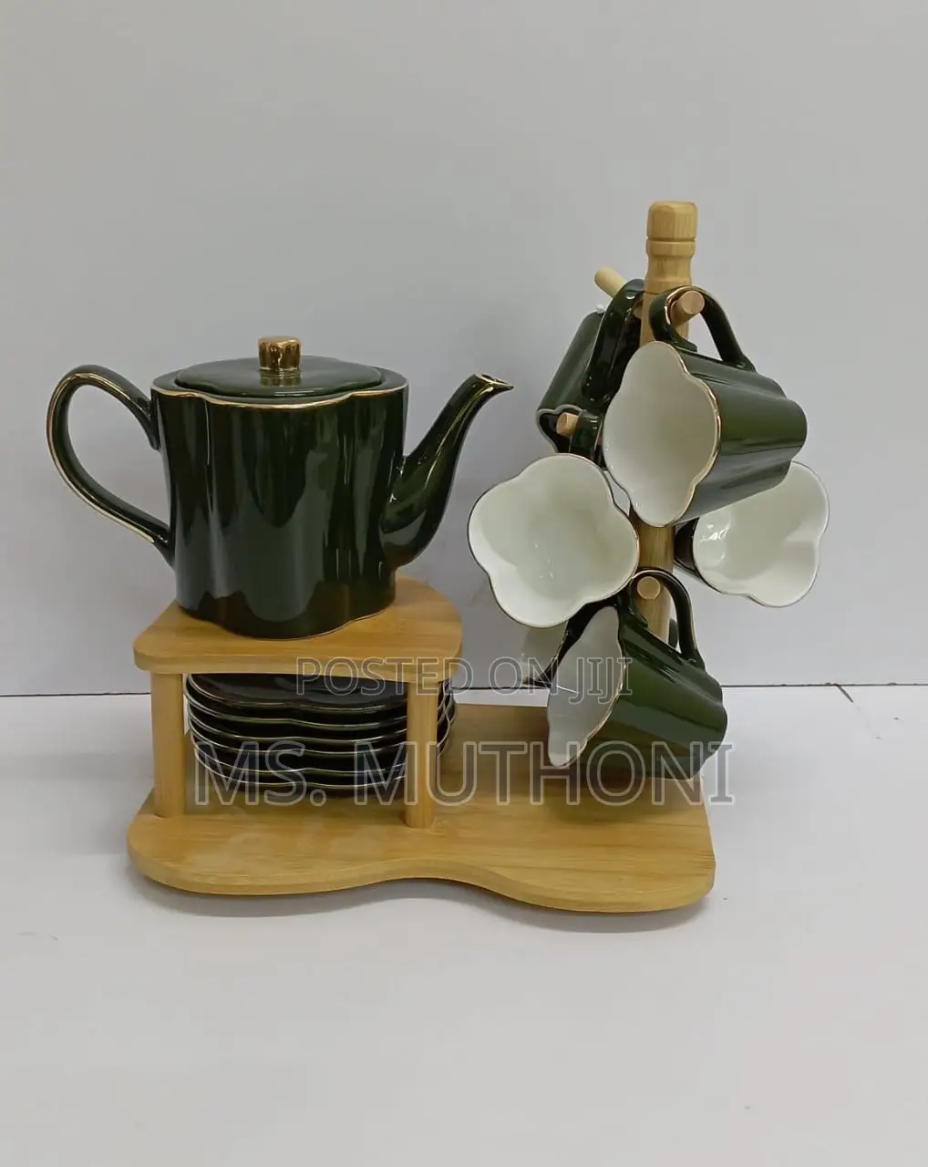 Ceramic Tea Set Featuring a Teapot, Cups, Saucers a Wooden Rack.
