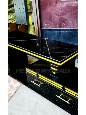 This Is a Black Wooden Tv Stand With a Marble Top and Gold Accents. 