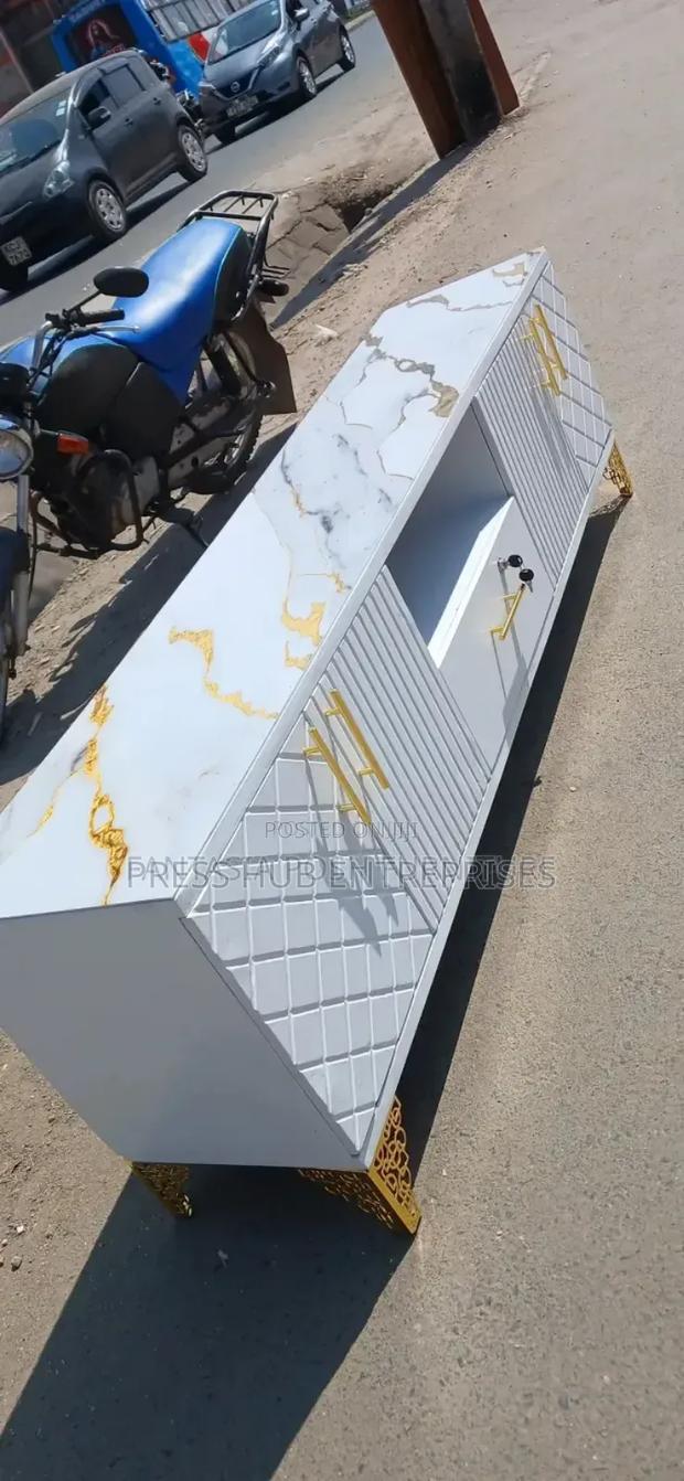 This Is a Black Wooden Tv Stand With a Marble Top in White"