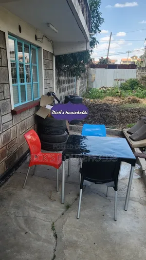 Red ,Black and Blue Plastic Chairs Plus a Square Plastic Table