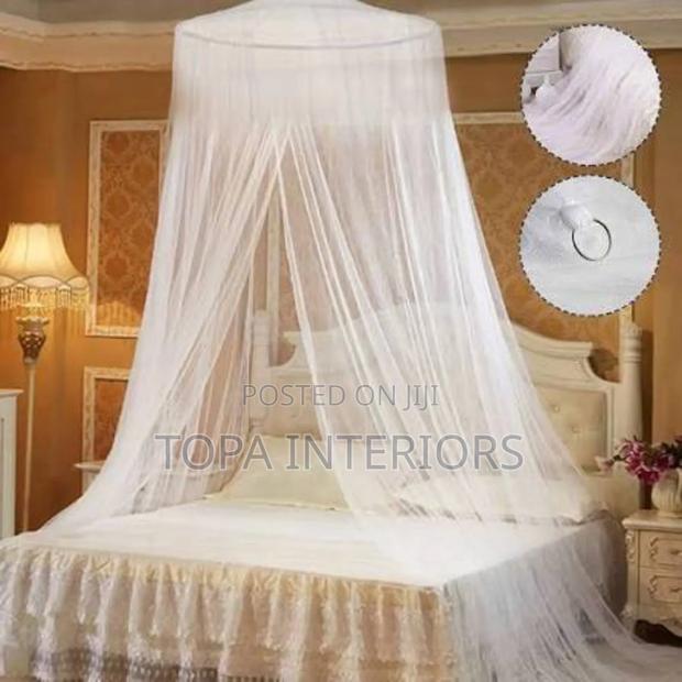 White Long Round Mosquito Bed Nets Hanging From the Ceiling