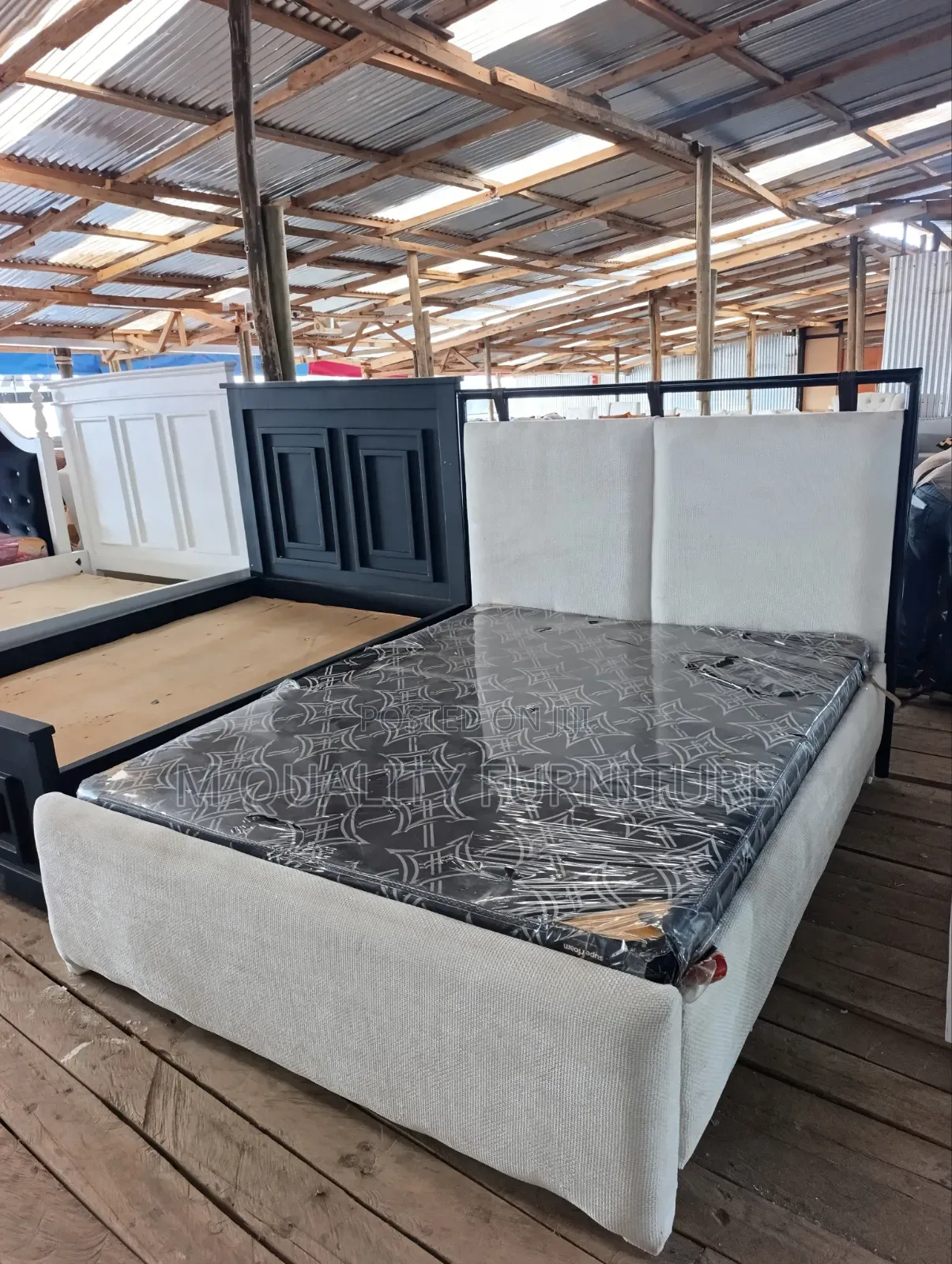 White Fabric Bed With a Black Stan