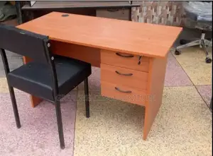 Wooden Office Desk With Three Drawers and a Black Metal Chair