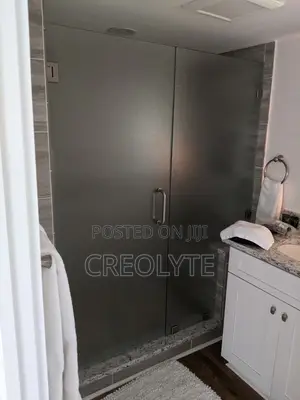 This Frameless Hinged Shower Door Features Frosted Glass