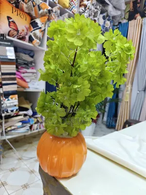 Artificial Green Flower in an Orange Vase