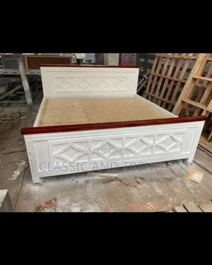 White Wooden Bed With a Decorative Carved Panel