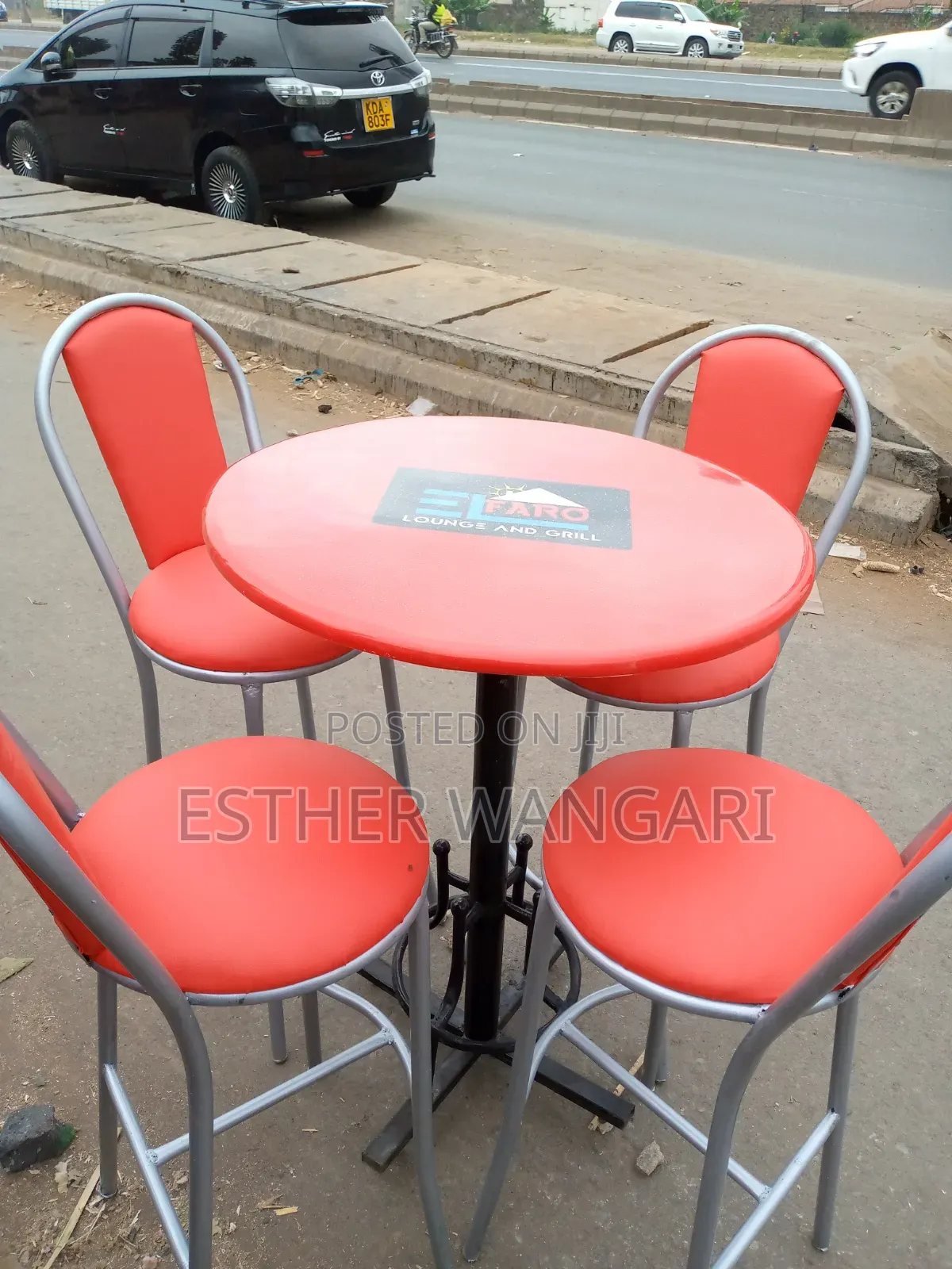 A Set of Red Painted Silver Hotel Chairs and a Table
