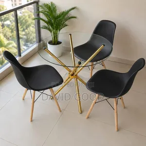 Golden Dining Table Round and Black Eames Chairs