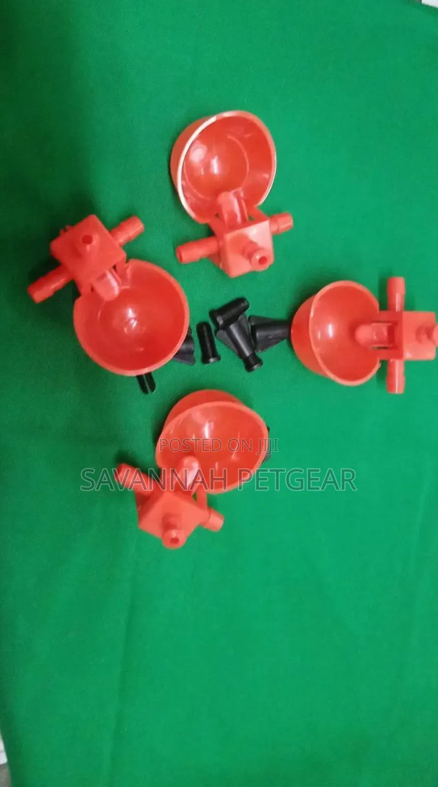 Red Plastic Automatic Poultry Drinking Cups Fitted Onto a Bucket