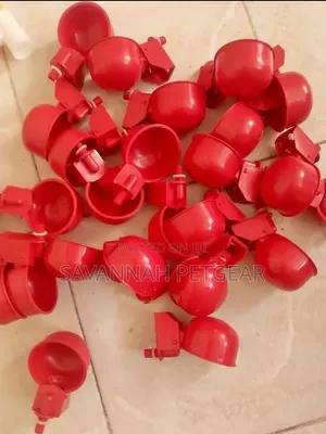 Red Plastic Automatic Poultry Drinking Cups Fitted Onto a Bucket