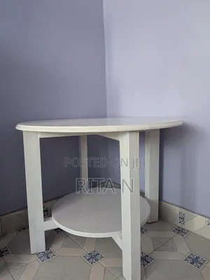 A Small White Wooden Table Perfect for a Living Room Setting