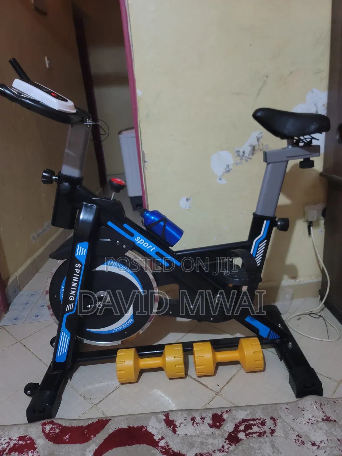 Fitness Bicycle Indoors With a Pair of Dumbells