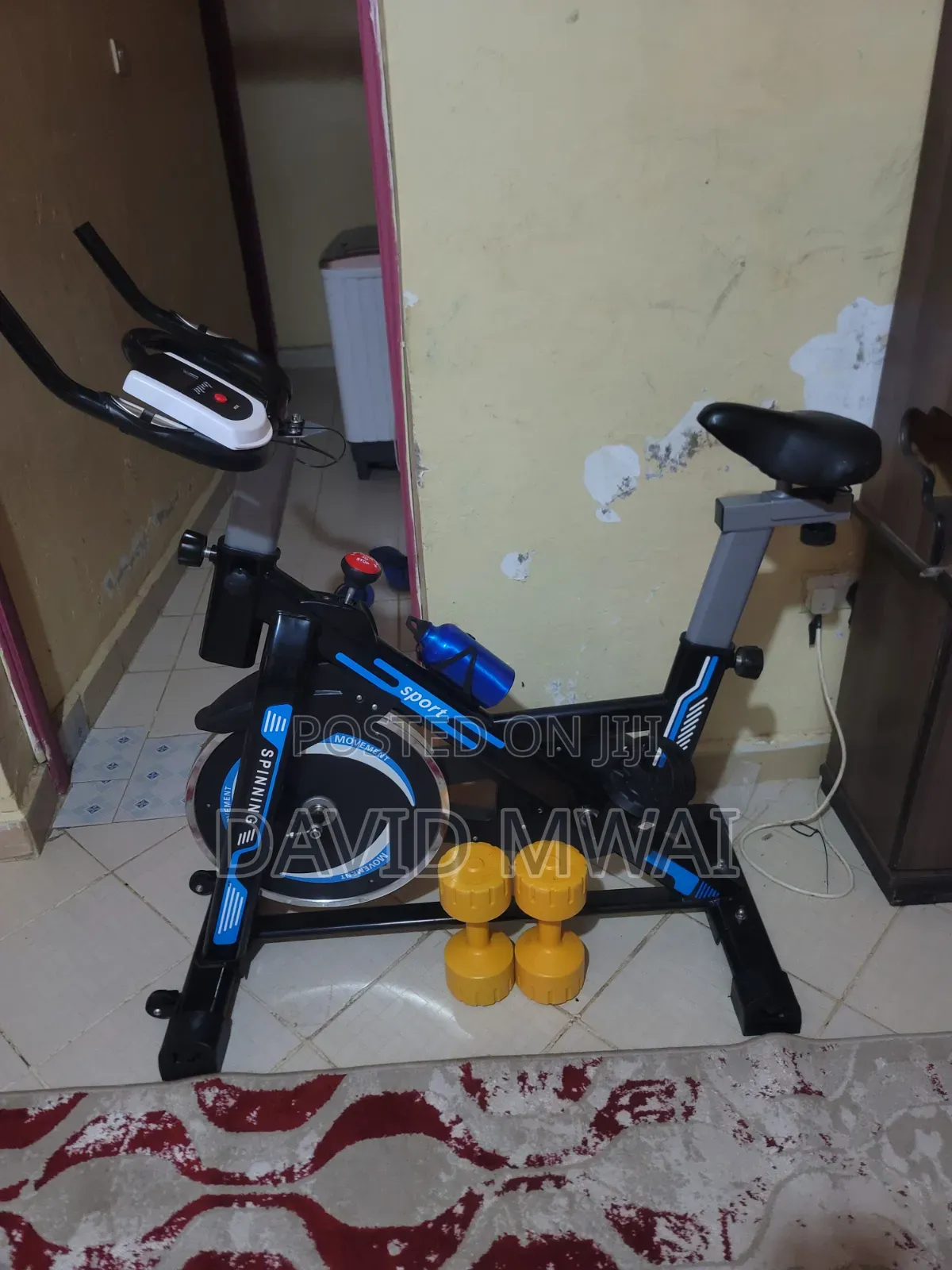 Fitness Bicycle Indoors With a Pair of Dumbells