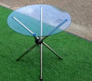 Round Glass-Top Table With a Distinctive Crossed Metal Leg Base