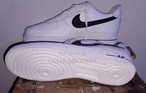 White Nike Air Force 1 '07 Low-Top Sneakers With a Black Swoosh.