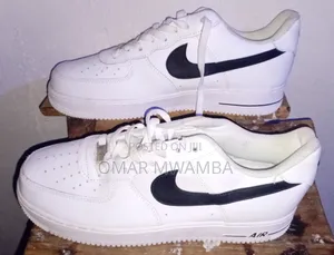White Nike Air Force 1 '07 Low-Top Sneakers With a Black Swoosh.
