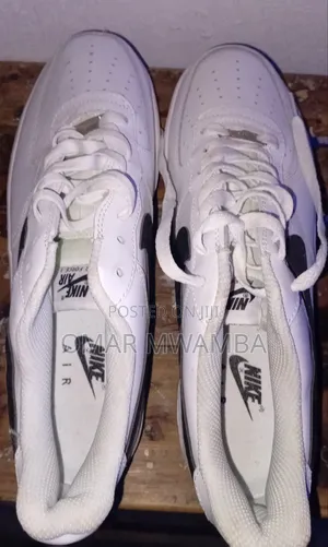 White Nike Air Force 1 '07 Low-Top Sneakers With a Black Swoosh.