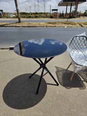 Elegant Round Glass Dining Table With Modern Black Base