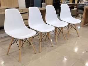 White Eames Plastic Chairs With Wooden Legs.
