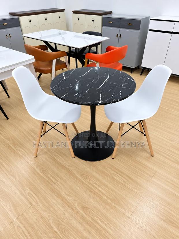 Modern Round Black Marble Dining Table With White Designer Chairs - main view