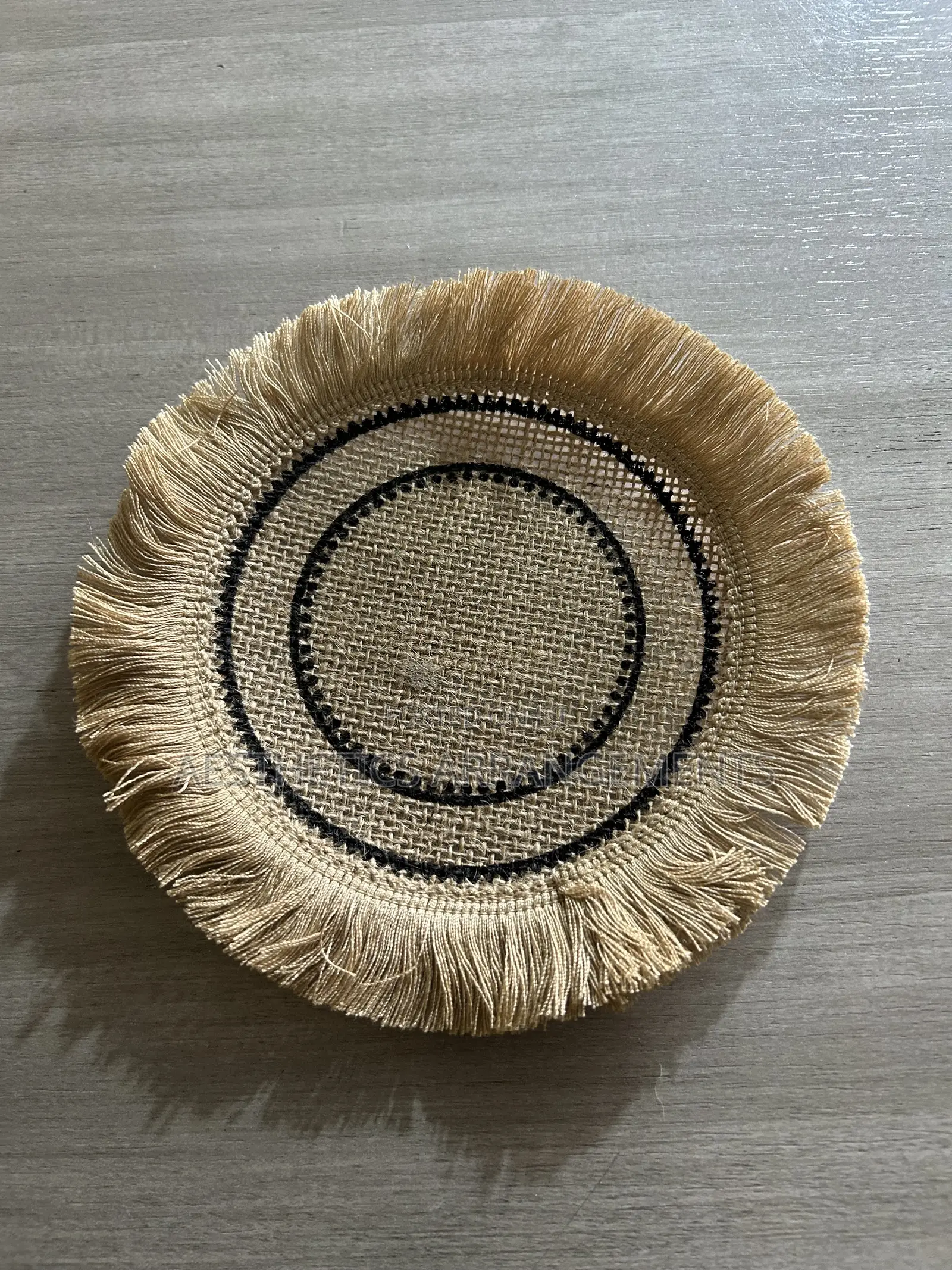 Brown Coaster With Black Inner Circles.