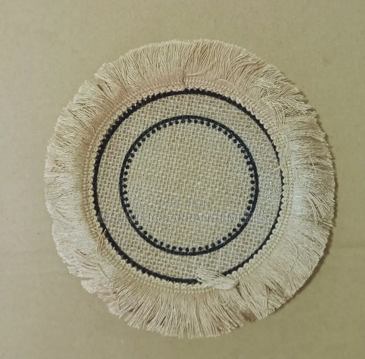 Brown Coaster With Black Inner Circles.